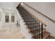 Beautiful staircase featuring hardwood steps, black metal railings, and white trim, adding a touch of elegance at 9810 Eagle Preserve Dr, Englewood, FL 34224