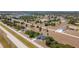 Wide aerial view of home in a community with many scattered homes, green space, and a pond in the distance at 10153 Gasparilla Rd, Placida, FL 33946