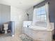 Bright bathroom featuring a freestanding tub, marble tiling, and a separate walk-in shower with pebble flooring at 10153 Gasparilla Rd, Placida, FL 33946