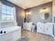 Spacious primary bathroom with dual vanities, a large window, and a separate soaking tub at 10153 Gasparilla Rd, Placida, FL 33946