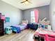 Bedroom featuring two beds, hardwood floors, gray walls, and a window with natural light at 10153 Gasparilla Rd, Placida, FL 33946