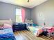 Bedroom featuring two beds, hardwood floors, gray walls, and a window with pink curtains at 10153 Gasparilla Rd, Placida, FL 33946