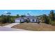 Spacious single-Gathering home with a large driveway and an adjacent yard, surrounded by lush trees and green spaces at 10153 Gasparilla Rd, Placida, FL 33946