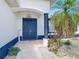 Inviting front entry featuring a blue front door, manicured landscaping, and a decorative hanging light fixture at 10153 Gasparilla Rd, Placida, FL 33946