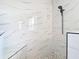 Walk-in shower with marble tiling, pebble flooring, and a matte black shower head at 10153 Gasparilla Rd, Placida, FL 33946