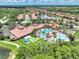 An aerial shot of a community featuring a pool, clubhouse, putting green, bocce ball, and neatly manicured lawns at 11186 Batello Dr, Venice, FL 34292