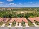 An aerial view displays the property nestled in a community with landscaping and scenic water views at 11186 Batello Dr, Venice, FL 34292