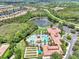 An aerial view of the community pool, amenity center, and well-manicured landscaping situated in a lush neighborhood at 11186 Batello Dr, Venice, FL 34292