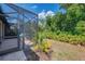 View of backyard with greenery and screened lanai at 11186 Batello Dr, Venice, FL 34292
