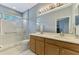 Bright bathroom featuring a double vanity, glass-enclosed shower, and modern fixtures at 11186 Batello Dr, Venice, FL 34292