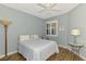 Cozy bedroom features wood floors, ceiling fan, and a sunny window with shutters at 11186 Batello Dr, Venice, FL 34292