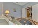 Cozy den featuring a comfortable sofa, hardwood floors, and soft lighting from a table lamp at 11186 Batello Dr, Venice, FL 34292