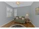Comfortable den with hardwood floors, a ceiling fan, sofa with pillows, and natural light at 11186 Batello Dr, Venice, FL 34292