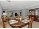 The dining area features a wood table set for dinner, with views of the living room and patio at 11186 Batello Dr, Venice, FL 34292