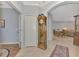 Inviting foyer with neutral tile flooring, a grandfather clock, and an arched entry to dining area at 11186 Batello Dr, Venice, FL 34292