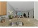 Bright kitchen with granite countertops, stainless sink, and view into the dining and living areas at 11186 Batello Dr, Venice, FL 34292