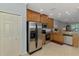 Updated kitchen with stainless steel refrigerator, granite counters, and wood cabinets at 11186 Batello Dr, Venice, FL 34292