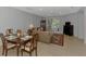 An open-plan living room and dining area featuring tile floors and sliding glass doors at 11186 Batello Dr, Venice, FL 34292