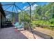 A screened-in patio features comfortable seating and serene views of lush greenery at 11186 Batello Dr, Venice, FL 34292