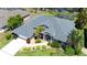 Aerial view of a beautiful home with lush landscaping, a driveway, and manicured lawn at 1124 W Hillsborough Blvd, North Port, FL 34288