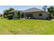 Large, grassy backyard with pool, screened in lanai, and plenty of space for outdoor activities at 1124 W Hillsborough Blvd, North Port, FL 34288