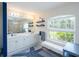 Bright bathroom with double sinks, lots of natural light, and a relaxing bench by the window at 1124 W Hillsborough Blvd, North Port, FL 34288