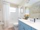 Bathroom featuring blue vanity, shower-tub combination and white tiling at 1124 W Hillsborough Blvd, North Port, FL 34288