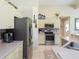 Bright kitchen with stainless steel appliances, tile backsplash, and light countertops at 1124 W Hillsborough Blvd, North Port, FL 34288