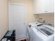 Laundry room with white washer and dryer, white cabinets, and storage space at 1124 W Hillsborough Blvd, North Port, FL 34288