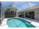 Beautiful backyard pool area with a screened-in patio and lush tropical landscaping at 1124 W Hillsborough Blvd, North Port, FL 34288