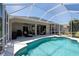 Refreshing pool with a screened-in patio and view of the well-manicured backyard at 1124 W Hillsborough Blvd, North Port, FL 34288