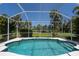 Inviting screened pool area with lush landscaping and clear blue skies above at 1124 W Hillsborough Blvd, North Port, FL 34288