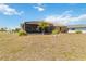 Backyard featuring a screened lanai and green space at 113 Mark Twain Ln, Rotonda West, FL 33947