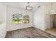 Dining room with wood-look flooring, a large window, and a modern chandelier at 113 Mark Twain Ln, Rotonda West, FL 33947