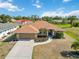 A well-maintained home featuring a two-car garage and landscaped front yard at 113 Mark Twain Ln, Rotonda West, FL 33947