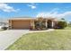 Charming single-story home with a two-car garage and manicured lawn at 113 Mark Twain Ln, Rotonda West, FL 33947