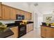 Kitchen with granite counters, wood cabinets, and black appliances at 113 Mark Twain Ln, Rotonda West, FL 33947