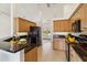 Well-lit kitchen with granite countertops, wood cabinetry, and modern black appliances at 113 Mark Twain Ln, Rotonda West, FL 33947