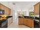 Well-appointed kitchen with stainless steel appliances and a view into the living room at 113 Mark Twain Ln, Rotonda West, FL 33947