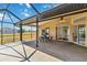 Enclosed lanai with a dining table, ceiling fan, and backyard access at 113 Mark Twain Ln, Rotonda West, FL 33947