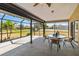 Enclosed lanai with a ceiling fan, dining table, and views of the backyard at 113 Mark Twain Ln, Rotonda West, FL 33947