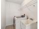 Functional laundry room equipped with a washer, dryer, utility sink, and practical shelving at 113 Mark Twain Ln, Rotonda West, FL 33947