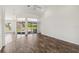Bright living room with wood-look flooring, large windows, and access to a screened lanai at 113 Mark Twain Ln, Rotonda West, FL 33947