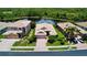 Beautiful aerial view of a home with well-manicured lawns, a brick driveway, and a serene pond view at 11437 Dancing River Dr, Venice, FL 34292