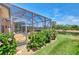 Beautiful backyard with a screened lanai, lush landscaping, and pond views at 11437 Dancing River Dr, Venice, FL 34292