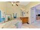 The bathroom features a soaking tub and wood vanity with updated lighting at 11437 Dancing River Dr, Venice, FL 34292