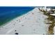 Panoramic view of a white sand beach with blue ocean and buildings in the distance at 11437 Dancing River Dr, Venice, FL 34292