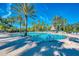 Resort-style community pool with ample seating and lush palm trees, creating a tropical oasis at 11437 Dancing River Dr, Venice, FL 34292