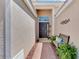 Elegant entryway with a dark front door, a charming bench, and beautiful landscaping adding to its appeal at 11437 Dancing River Dr, Venice, FL 34292