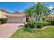 Charming single-story home with a brick driveway, lush landscaping, and a two-car garage at 11437 Dancing River Dr, Venice, FL 34292